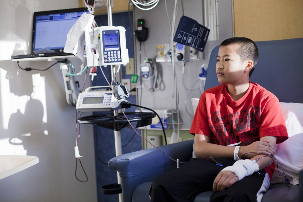 a child sitting in a hospital chair